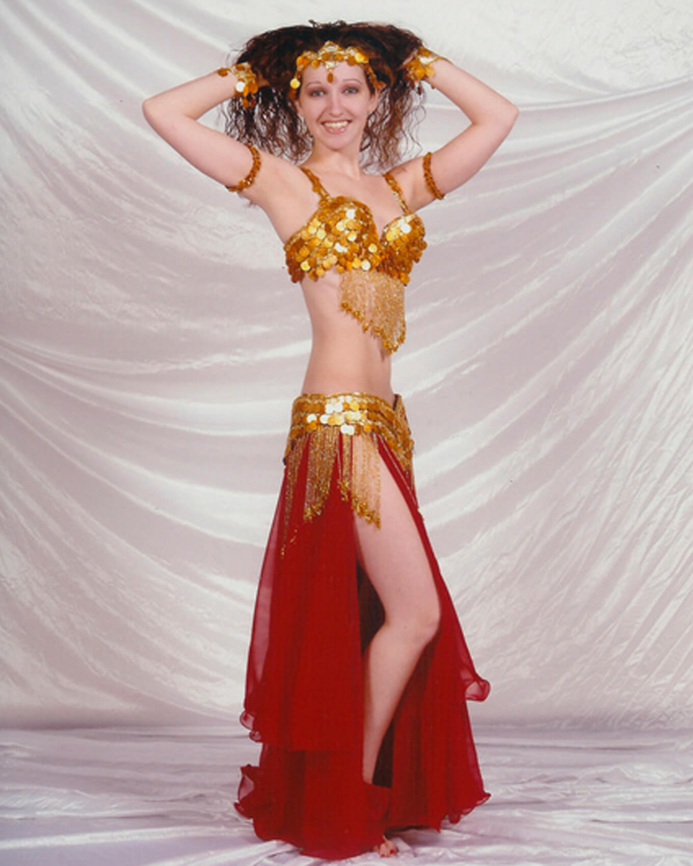 Donna wearing one of her red and gold belly dance outfits